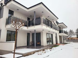 a white house with a balcony in the snow at Modern Living in Budapest in Budapest