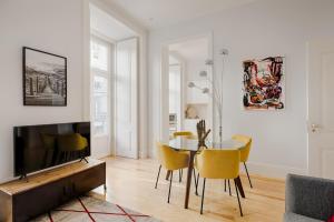 uma sala de estar com uma mesa e cadeiras amarelas em Architectural Gem in Baixa em Lisboa