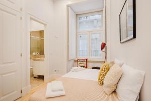 uma sala de estar com um sofá branco e uma janela em Architectural Gem in Baixa em Lisboa