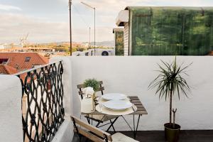 a patio with a table and chairs on a balcony at Romantic Gem with 2 Terraces in Alcântara in Lisbon