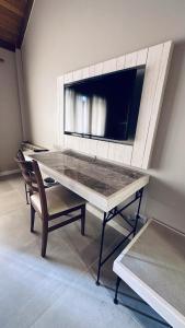 a table with chairs and a tv on a wall at Tolkeyen Ushuaia Hotel in Ushuaia