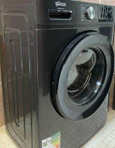 a black washing machine with a shoe inside of it at ستوديو كبير غرفة و حمام بمكيف غسالة تلفاز واي فاي in Al-Salam