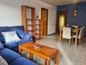 sala de estar con sofá azul y mesa en Pis de l'Hereu. en Pobla de Segur