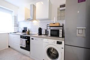 cocina con lavadora y microondas en 2 bedrooms apartment Wolewe-Saint-Lambert (Diamant), en Bruselas