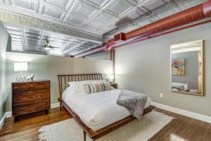 a bedroom with a large bed and a mirror at Good Vibes Loft - DT CLE Walk To All The Stadiums in Cleveland