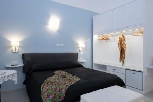 sypialnia z czarnym łóżkiem i biurkiem w obiekcie Amalfi Casa Angelina w Amalfi