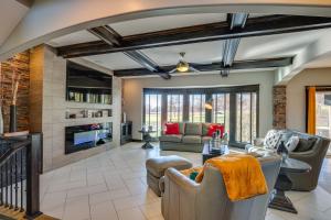 a living room with couches and a fireplace at Luxe Missouri Getaway with Hot Tub and Fire Pit! in Oak Grove