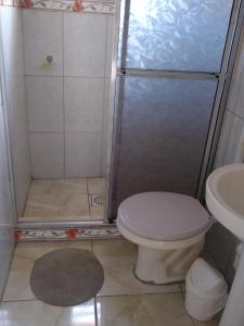 a bathroom with a shower with a toilet and a sink at Apartamento família perto do mar in Tramandaí +29 photos