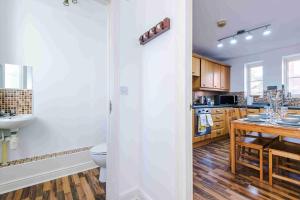 a kitchen with a toilet and a sink and a table at Inviting 3-Bedroom House in Warrington with Parking and Free Wifi by Amazing Spaces Relocations Ltd. in Warrington