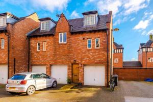 a white car parked in front of a brick house at Inviting 3-Bedroom House in Warrington with Parking and Free Wifi by Amazing Spaces Relocations Ltd. in Warrington