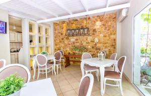 a dining room with tables and chairs and a brick wall at Hotel Galini in Limenas +43 photos