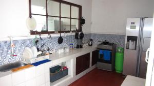 a kitchen with a sink and a refrigerator at Hostal prado colonial in Medellín