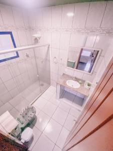 ein Bad mit einer Dusche, einem WC und einem Waschbecken in der Unterkunft Casa com churrasqueira e 3 quartos - Centro in Búzios