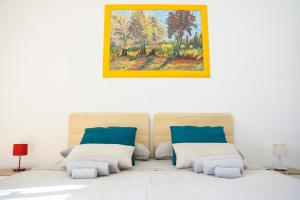a bedroom with a bed with a painting on the wall at Casa Vittoria in LʼAquila