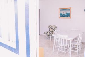 ein weißes Esszimmer mit einem weißen Tisch und Stühlen in der Unterkunft Casa com churrasqueira e 3 quartos - Centro in Búzios