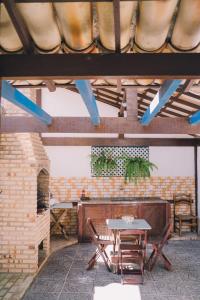 eine Terrasse mit einem Tisch, Stühlen und einem Kamin in der Unterkunft Casa com churrasqueira e 3 quartos - Centro in Búzios