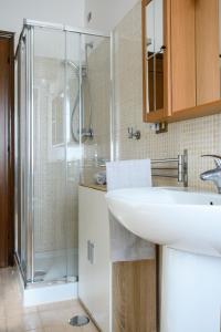 a bathroom with a sink and a glass shower at Casa Vittoria in LʼAquila