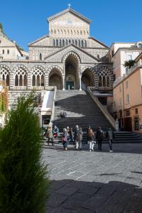grupa ludzi przechodzących przed budynkiem w obiekcie Amalfi Casa Angelina w Amalfi