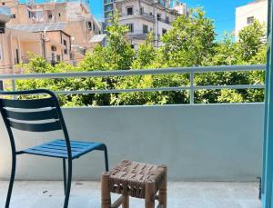 einen blauen Stuhl und einen Stuhl auf dem Balkon in der Unterkunft Stone Wall 2BR Apartment in Beirut