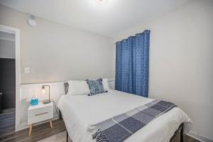 a bedroom with a bed and a blue curtain at The Metropolitan Manor-new Corporate Apt Downtown in Grand Rapids
