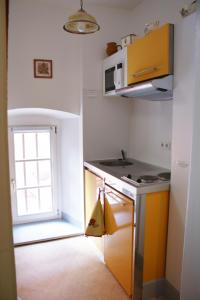 eine kleine Küche mit einem Waschbecken und einem Fenster in der Unterkunft Location "Charme" in Riquewihr
