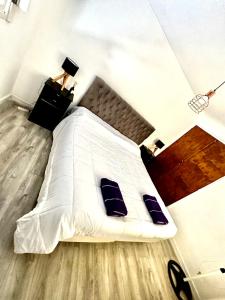 a bedroom with a white bed with two blue pillows at San Miguel departamentos in Trelew