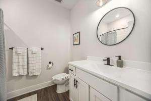 a white bathroom with a sink and a mirror at The Urban Oasis -brand New Corporate Apt Downtown in Grand Rapids +7 photos