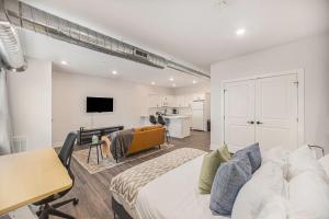 a bedroom with a bed and a desk and a kitchen at The Urban Oasis -brand New Corporate Apt Downtown in Grand Rapids