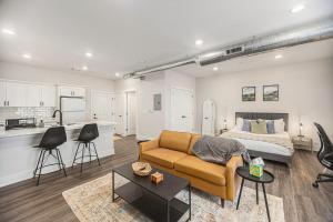 a living room with a couch and a bed and a kitchen at The Urban Oasis -brand New Corporate Apt Downtown in Grand Rapids