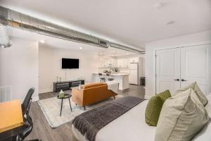 a bedroom with a bed and a living room and a kitchen at Modern Manor - Brand New Corporate Apt Downtown in Grand Rapids