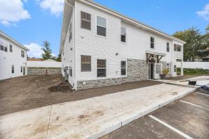 a large white building with a parking lot at Modern Manor - Brand New Corporate Apt Downtown in Grand Rapids