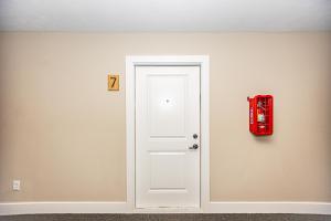 een witte deur met een rode brandkraan aan een muur bij Modern Manor - Brand New Corporate Apt Downtown in Grand Rapids