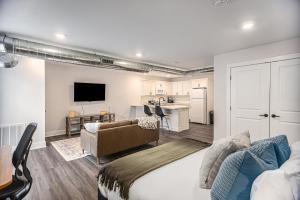 a bedroom with a bed and a living room with a kitchen at Upscale Abode - Brand New Corporate Apt Downtown in Grand Rapids