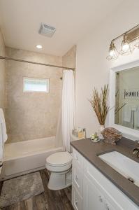 a bathroom with a toilet and a tub and a sink at Mills Fishing Cabin in Port Aransas +20 photos