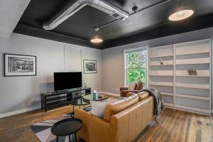 sala de estar con sofá y TV en The Loft Life - Modern Corporate Housing, en Grand Rapids