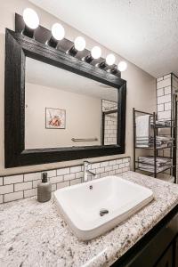 a bathroom with a white sink and a mirror at The Loft Life - Modern Corporate Housing in Grand Rapids