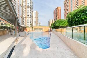 uma piscina numa cidade com edifícios altos em habitacion familiar frente al mall plaza buena vista em Barranquilla