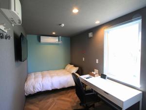 1 dormitorio con 1 cama y escritorio con escritorio en HOTEL KUTEKUN - Vacation STAY 31431v, en Naka-shibetsu