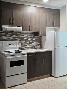 a kitchen with a white stove and a refrigerator at Western Budget Motel #1 Leduc/Nisku in Leduc