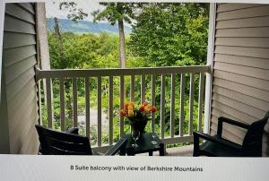 a vase of flowers on a table on a balcony at Vacation Village in The Berkshires in Hancock