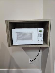 a microwave on a shelf in a wall at Western Budget Motel #1 Leduc/Nisku in Leduc