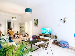 ein Wohnzimmer mit einem Sofa und einem TV in der Unterkunft Garden View Apt 4BR Beirut in Beirut