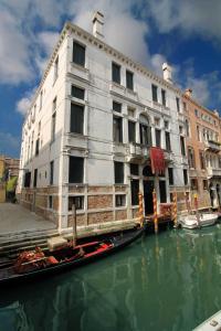 a building on a canal with a boat in the water at Hotel Palazzo Abadessa in Venice