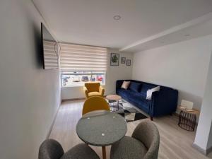 sala de estar con sofá azul y mesa en Apartamento Barrio La Felicidad, en Bogotá