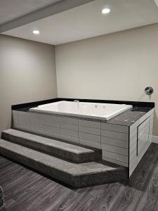 a bath tub in a room with stairs at Western Budget Motel #1 Leduc/Nisku in Leduc