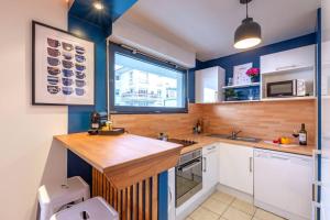 a kitchen with a counter with a sink and a window at Artémis-10 min. from Versailles Gardens, parking in Le Chesnay