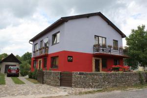 a red and white house with a brick wall at Galleria Betliar in Betliar