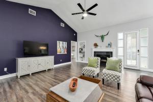 a living room with a tv and a couch and chairs at Water Well Wonder in Austin