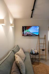 a living room with a couch and a flat screen tv at YOLO Resort- Giardino in Alykes