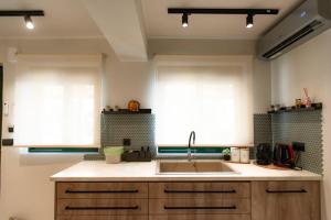 a kitchen with a sink and two windows at YOLO Resort- Giardino in Alykes +28 photos